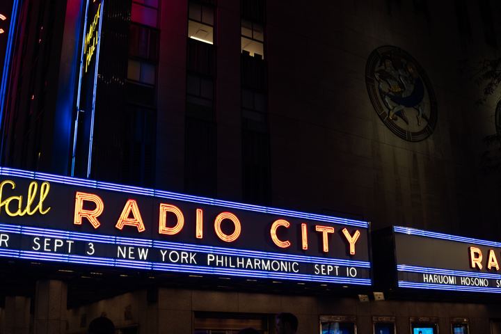 The Radio City Music Hall marquee in blue and orange neon.
