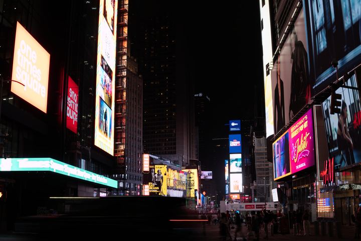 Times Square screens above an empty wet crossing.